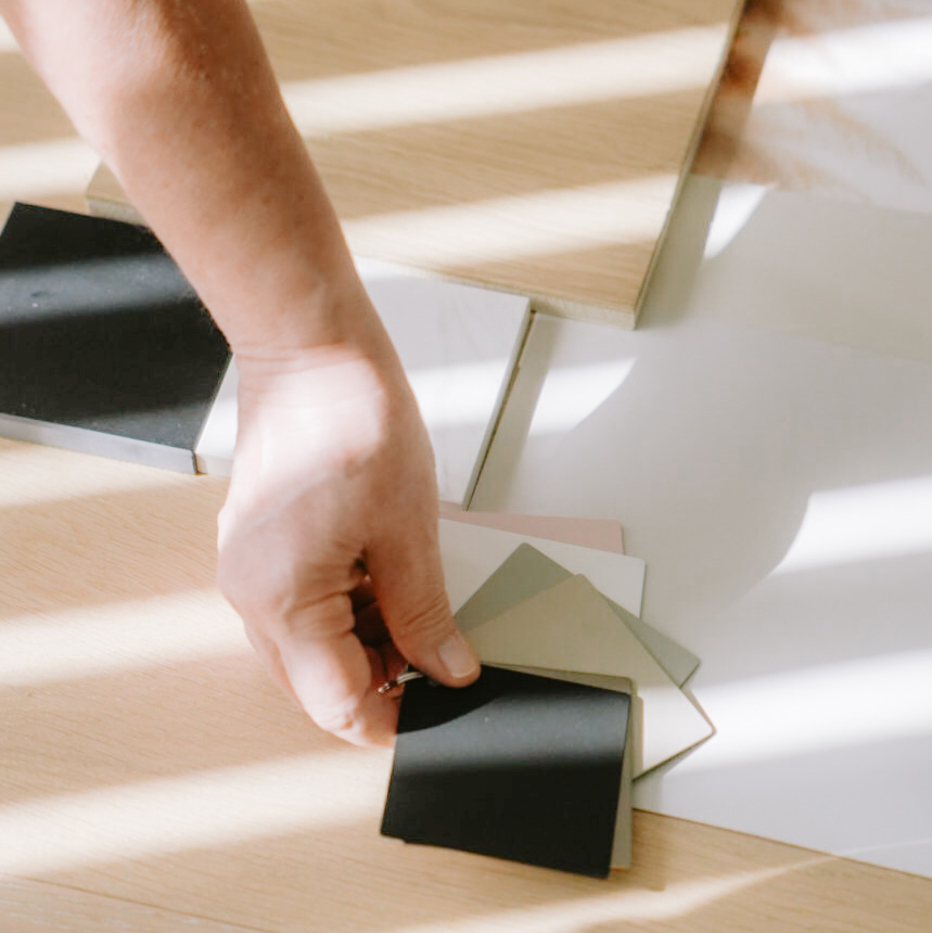 Käsi, joka sommittelee sisustuselementtejä