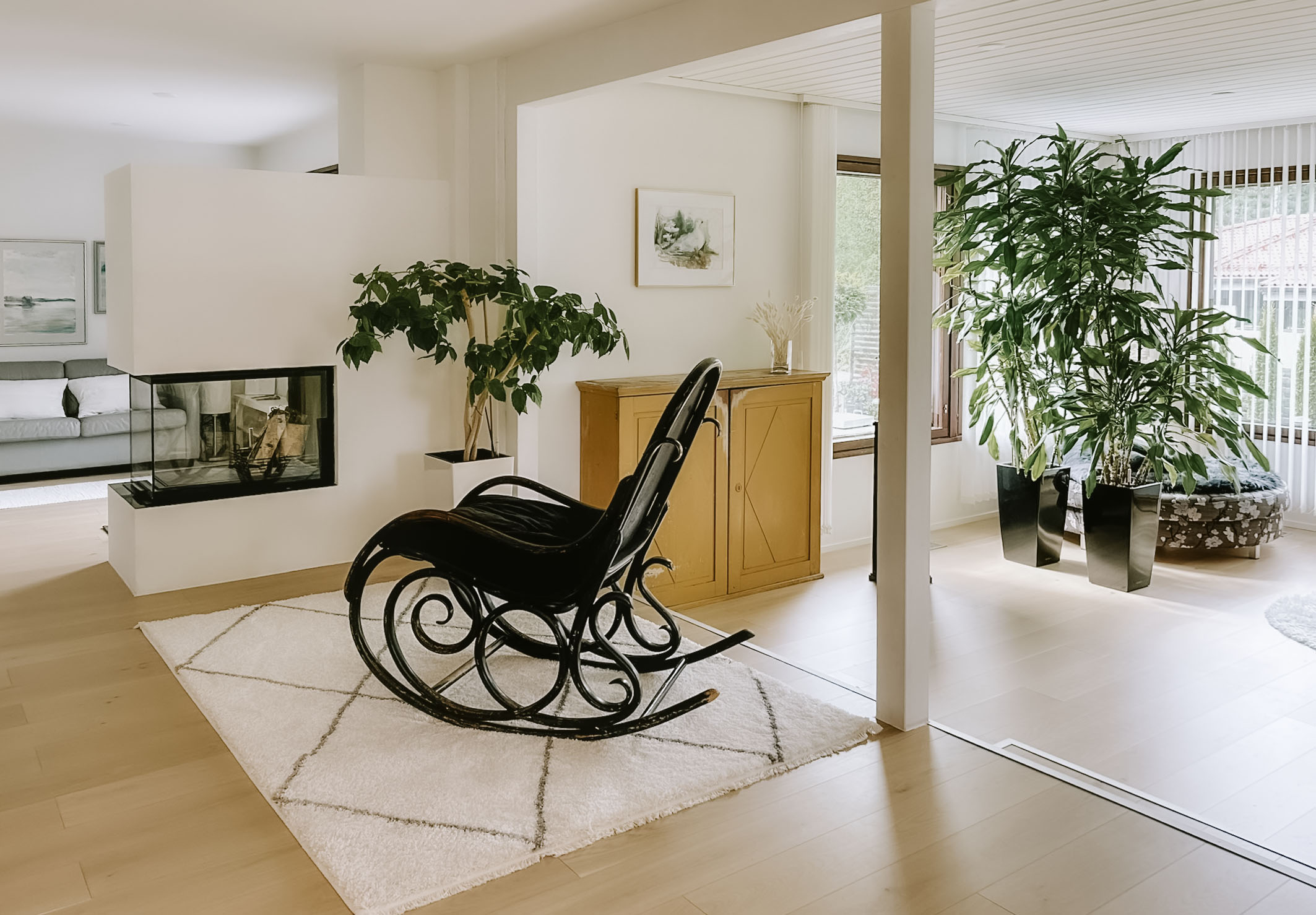 Oleskelutila, jossa keinutuoli ja takka